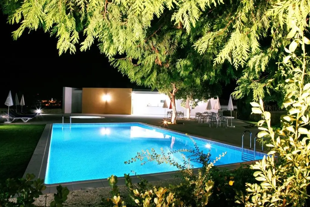 Hotel Quinta Progresso outdoor swimming pool at night with garden and patio
